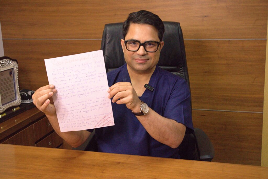 Dr. Vivek Vij holding a handwritten thank-you letter from the daughter of a liver transplant patient following a successful world-first laparoscopic dual-lobe living donor liver transplant.